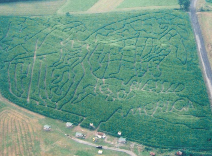 Corn maze design depicting a US map, a cross, and "God Bless America"